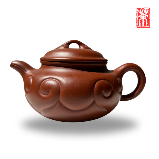 Ergänzen Sie Ihre Teekollektion mit dieser eleganten Yixing Teekanne aus rötlichem Zisha-Ton. Die lebendige, helle Tonfarbe und das kunstvoll eingearbeitete Wolkenrelief machen sie zum Blickfang – perfekt, um die erdigen Aromen von Pu-Erh und dunklen Tees stilvoll zu genießen.